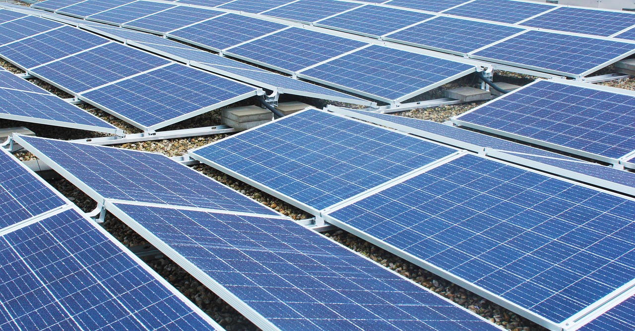 Aufgeständerte Photovoltaikmodule in mehreren Reihen auf einem Kiesflachdach