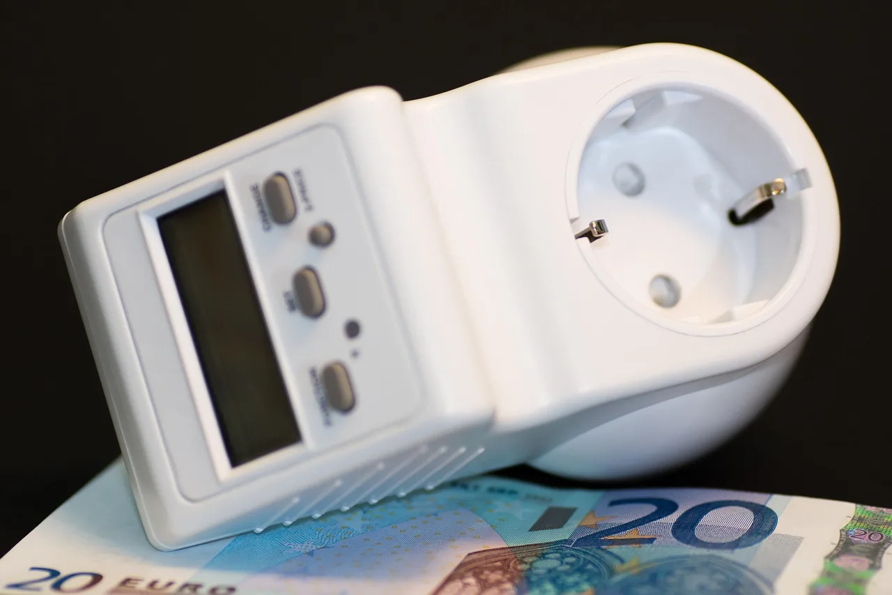 Digitales Energiekosten-Messgerät auf einem 20-Euro-Schein, das den Stromverbrauch anzeigt.