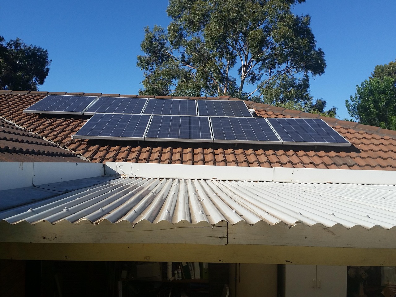 Kleine Aufdach-Photovoltaikanlage mit wenigen Solarmodulen auf einem verwitterten Ziegeldach